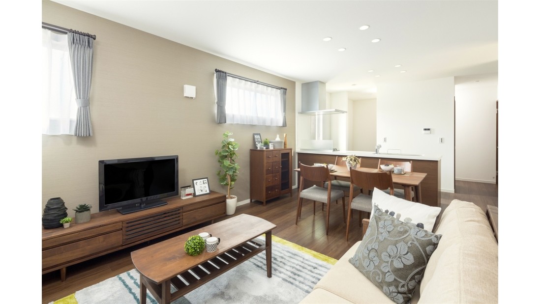 リビングの床はダークブラウンを採用。それによって全体的に落ち着いた雰囲気になり、アクセントクロスにファブリック系のグレーをいれ、さらに大人の雰囲気を演出しています。