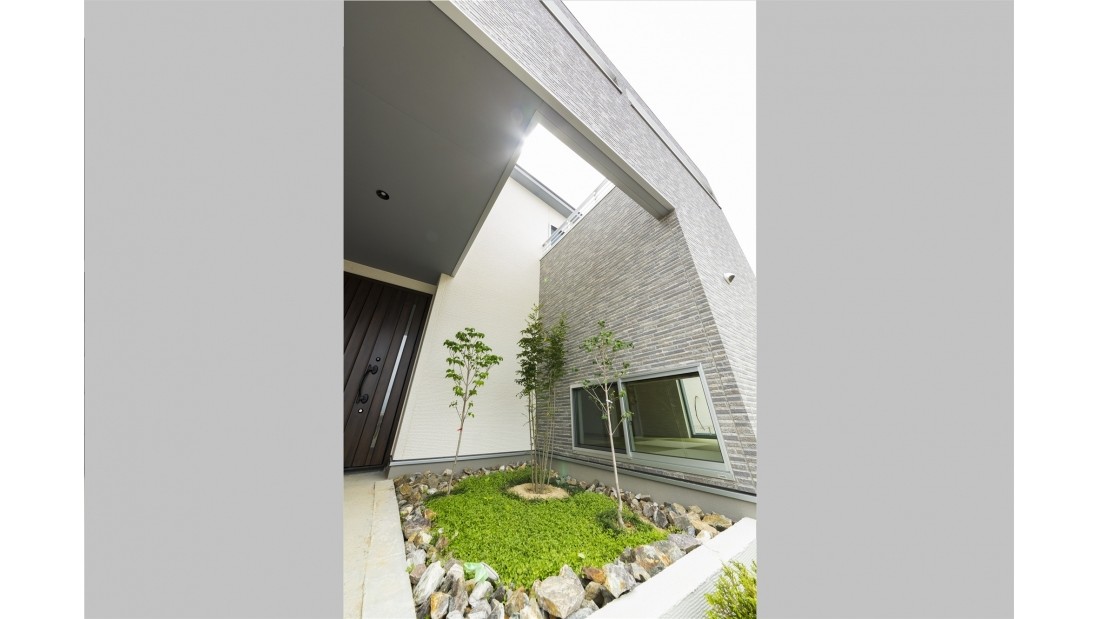 バルコニーの間を縫って陽光が降り注ぐ玄関先の坪庭が、出入りする際に癒しを与えてくれます。