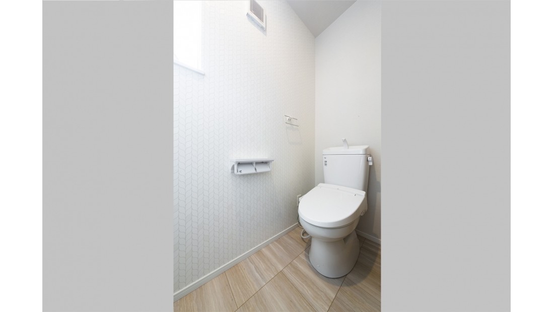 トイレの壁紙には落ち着きあるホワイトのリーフ柄を採用し、ナチュラル空間を演出しています。