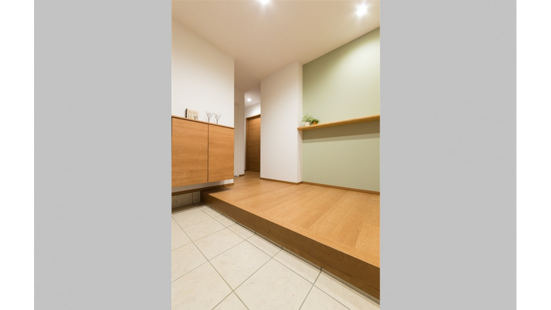 広い間口で使いやすい玄関は、正面の壁にアクセントクロスと飾り棚を配置し、住まいが訪れる人を出迎えるイメージで設計。