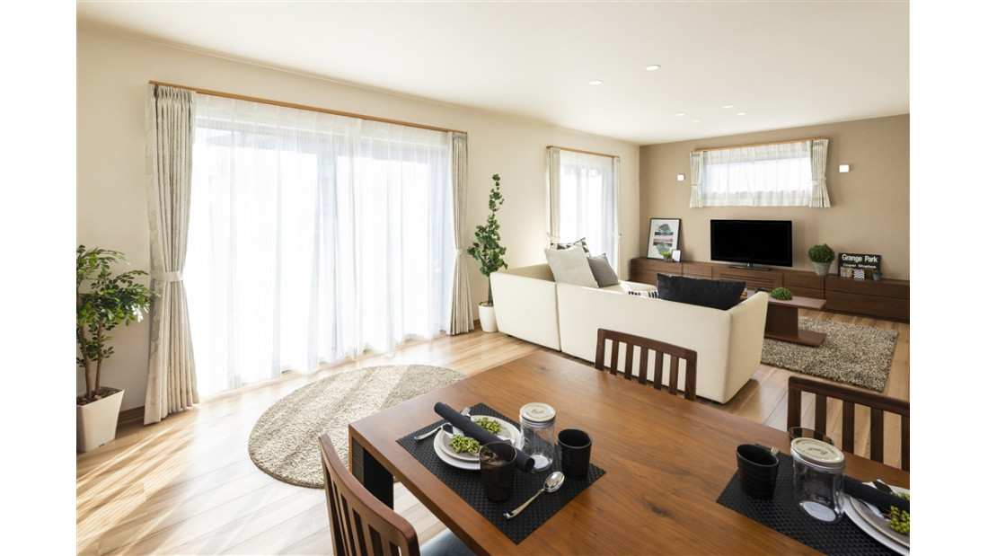 ホワイト一色の壁紙に、アースカラーのアクセントクロスを配置するだけで一気にナチュラルテイストへ。陽光が似合う気品あるリビング。