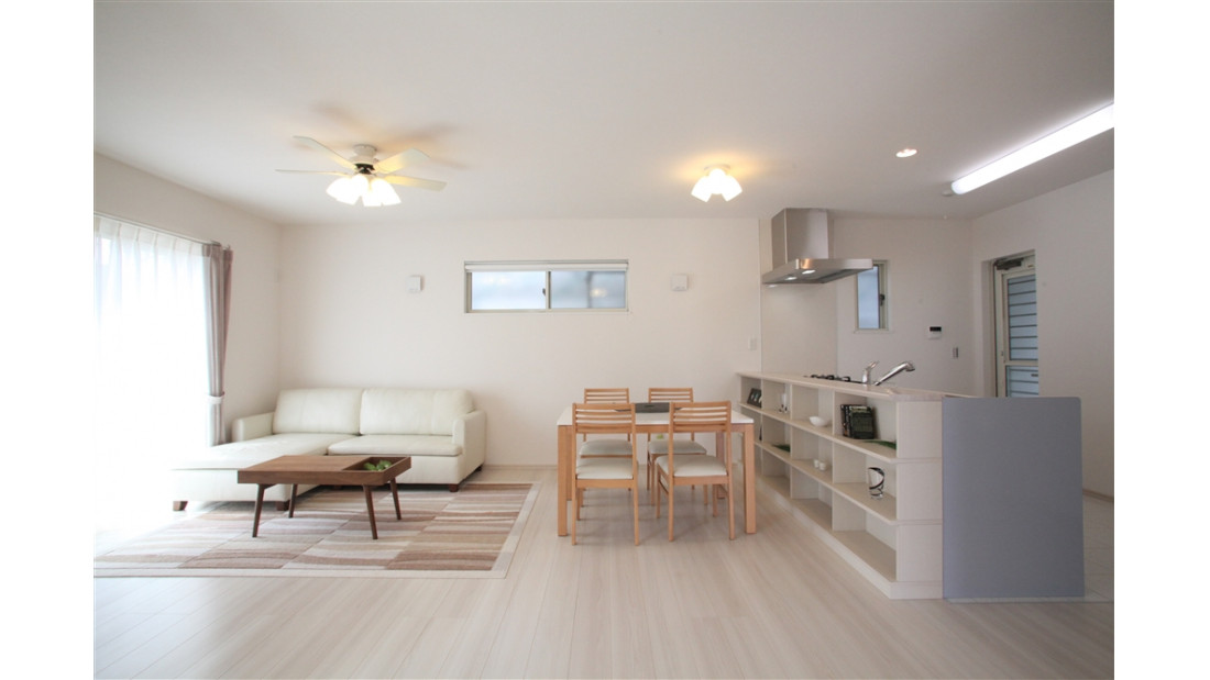 白基調のクロスにはシンプルな木質の家具が似合う北欧スタイルの住まい。キッチンの背面には作りつけの収納棚を設置し、インテリアを飾ったり収納として使用したりと用途が広がります。差し色でビビットなアイテムを置くと、より北欧テイストが広がります。